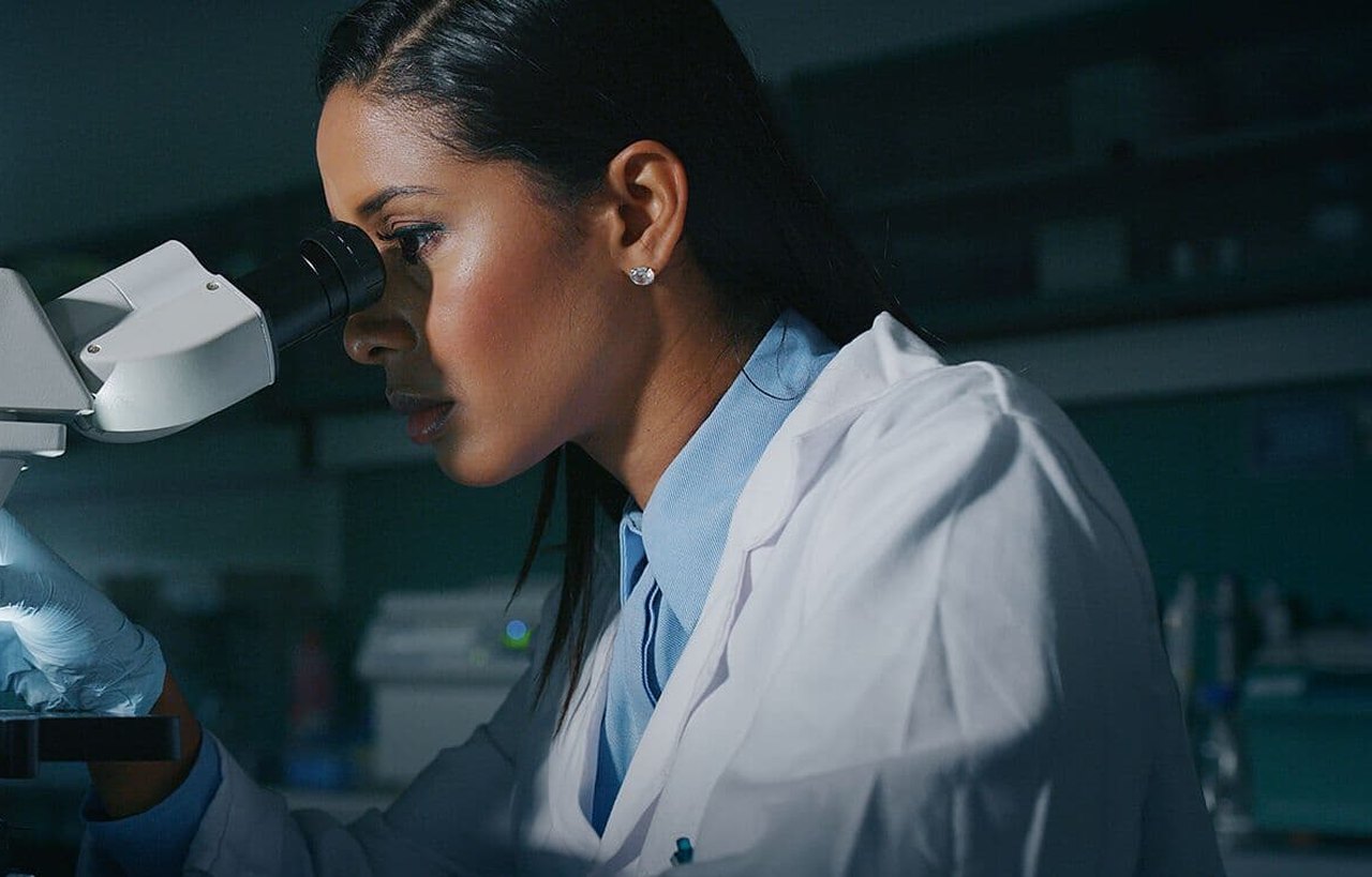 Researcher looking through a microscope