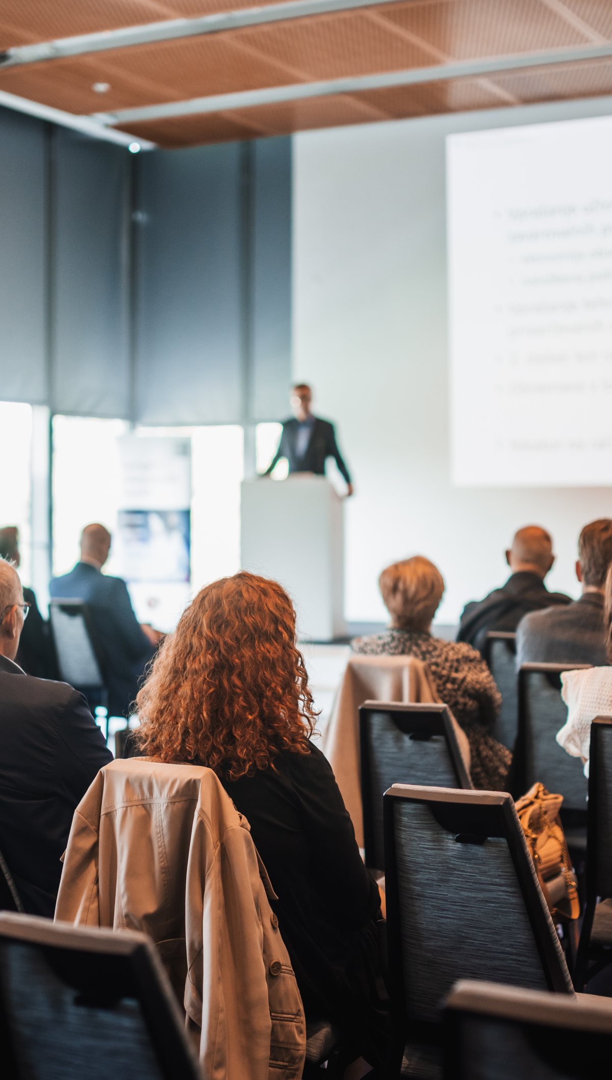 A speaker presenting to an audience at a conference
